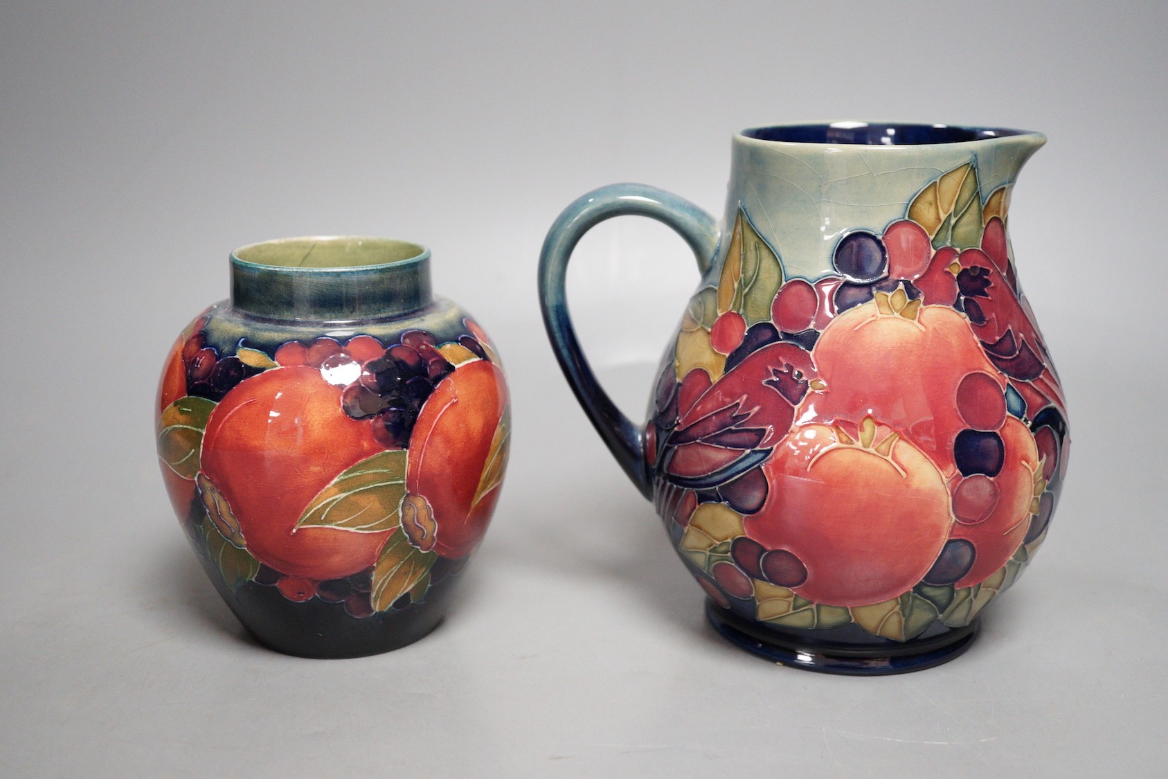 A Moorcroft finch and berry jug and a Moorcroft pomegranate jar, tallest 15cm